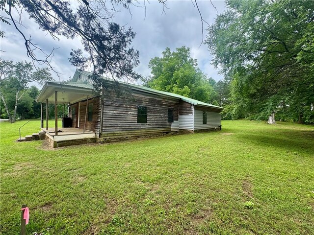 171 Tate St, Atkins, AR 72823 - rear view of house featuring a lawn and covered porch