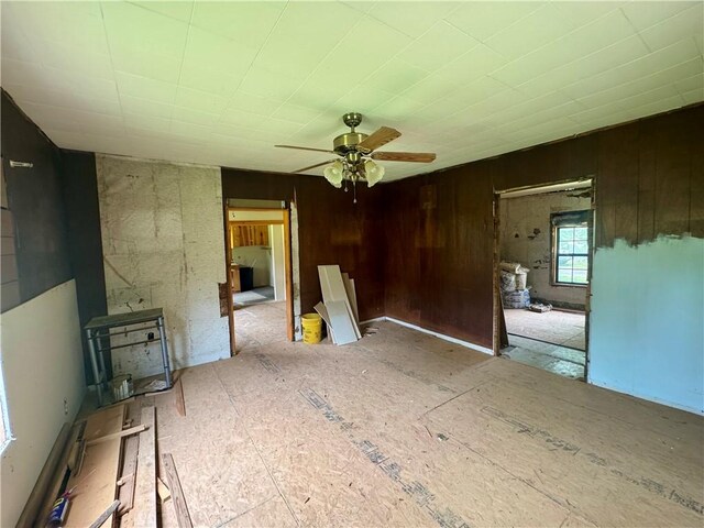 171 Tate St, Atkins, AR 72823 - unfurnished living room featuring a ceiling fan and wooden walls