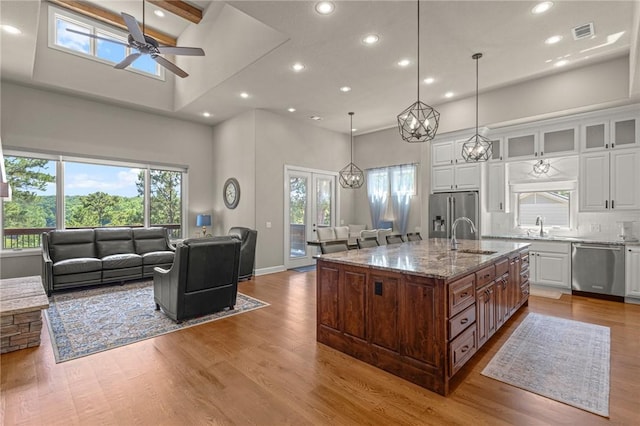 42 Devizis Dr, Bella Vista, AR 72714 - kitchen featuring appliances with stainless steel finishes, open floor plan, a sink, a towering ceiling, and recessed lighting