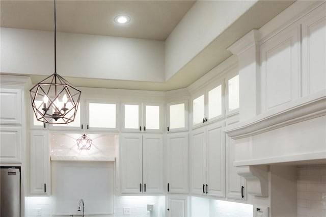42 Devizis Dr, Bella Vista, AR 72714 - kitchen view of fridge, a chandelier, decorative light fixtures, white cabinets, and recessed lighting