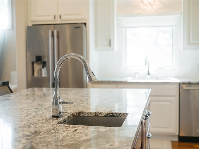42 Devizis Dr, Bella Vista, AR 72714 - kitchen with appliances with stainless steel finishes, a sink, light stone counters, and white cabinetry