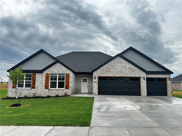 7695 Teton Trl, Springdale, AR 72762 - modern inspired farmhouse with an attached garage, concrete driveway, a front yard, brick siding, and board and batten siding