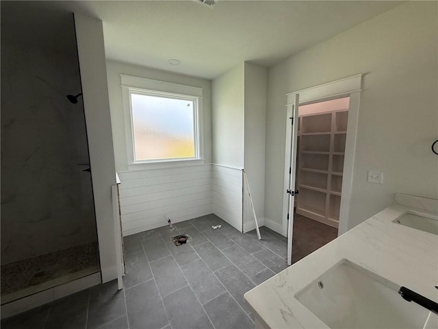 7695 Teton Trl, Springdale, AR 72762 - bathroom featuring walk in shower, double vanity, tile patterned flooring, and a wainscoted wall