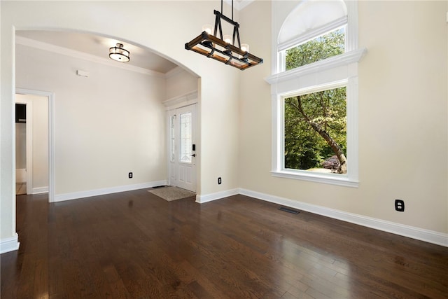 17 Webbly Ln, Bella Vista, AR 72714 - entryway featuring arched walkways, plenty of natural light, dark wood-style flooring, ornamental molding, and a towering ceiling