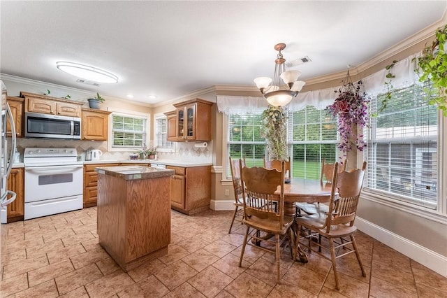 4931 Dogwood, Springdale, AR 72762 - kitchen featuring white range with electric stovetop, stainless steel microwave, crown molding, baseboards, and glass insert cabinets