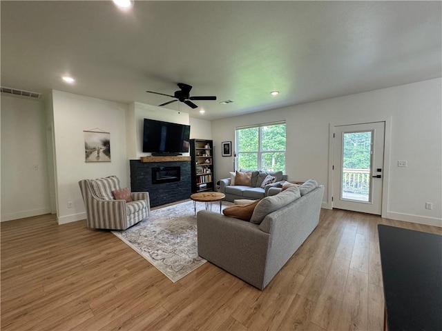 1 Llanon Cir, Bella Vista, AR 72714 - living area with light wood finished floors, a ceiling fan, baseboards, a stone fireplace, and recessed lighting