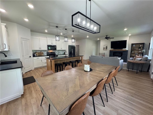 1 Llanon Cir, Bella Vista, AR 72714 - dining area with a ceiling fan, light wood-style floors, a fireplace, and recessed lighting
