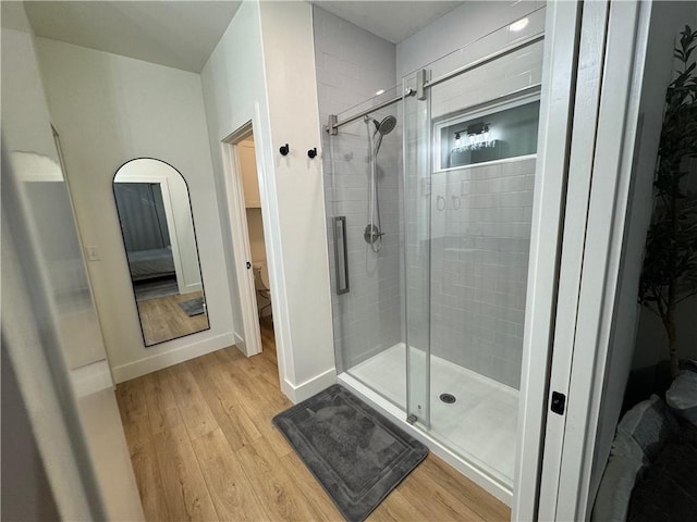 1 Llanon Cir, Bella Vista, AR 72714 - ensuite bathroom featuring wood finished floors, a shower stall, toilet, and baseboards
