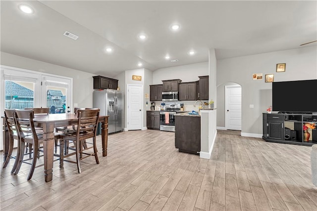200 Post Oak Ave, Gentry, AR 72734 - kitchen with stainless steel appliances, light wood-style floors, dark brown cabinetry, arched walkways, and recessed lighting