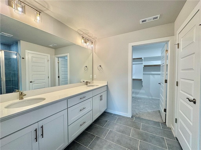 480 S Benchmark Ln, Fayetteville, AR 72704 - bathroom featuring double vanity, a stall shower, a spacious closet, tile patterned flooring, and baseboards