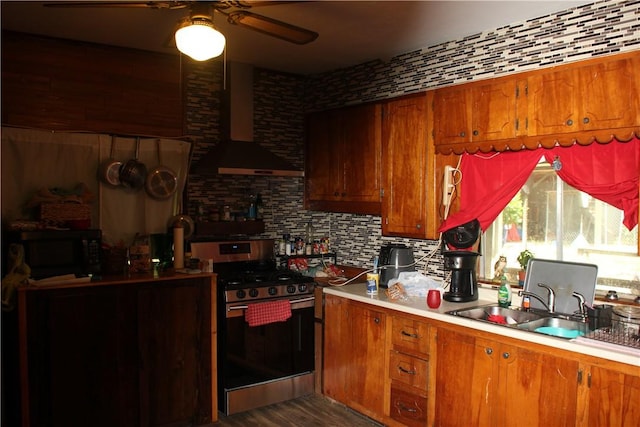 197 7th St, Saint Paul, AR 72756 - kitchen featuring stainless steel gas range oven, black microwave, brown cabinetry, wall chimney exhaust hood, and a sink