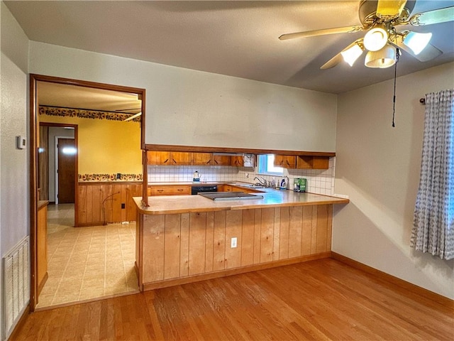 102 Pecan St, Marshall, AR 72650 - kitchen with a peninsula, brown cabinets, light wood finished floors, backsplash, and light countertops