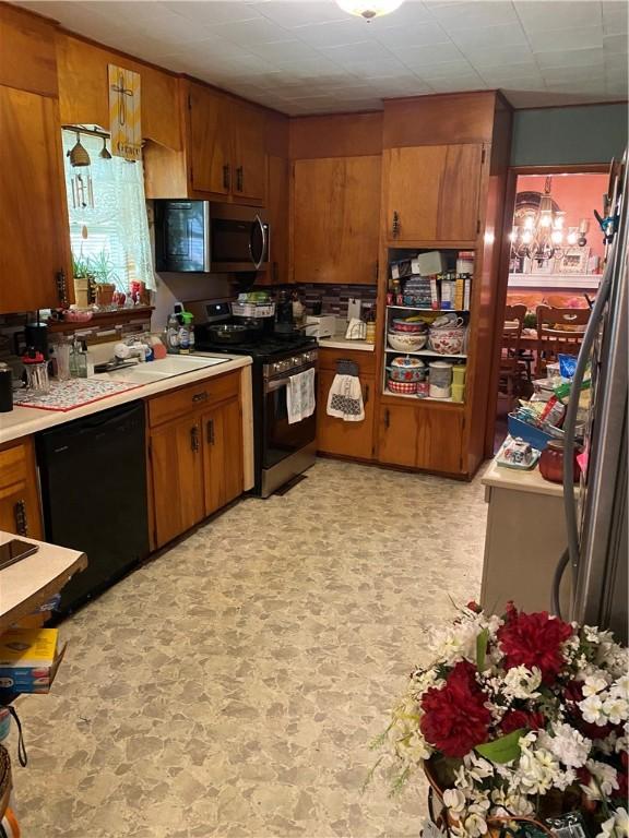 924 W Ave, Lincoln, AR 72744 - kitchen with stainless steel appliances, brown cabinetry, light countertops, and a sink