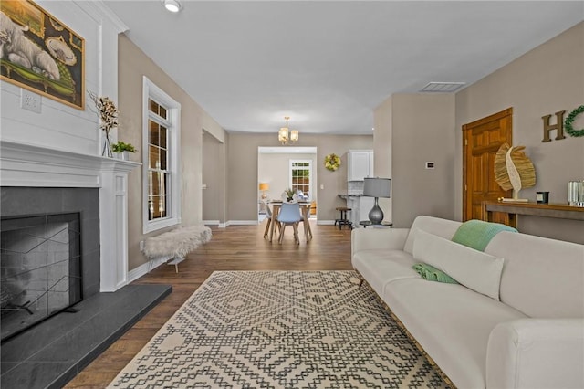 1 Geyer Rd, Bentonville, AR 72712 - living room featuring dark wood finished floors, a chandelier, and a fireplace with raised hearth
