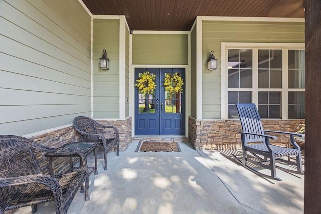 26 Primrose Ln, Bella Vista, AR 72714 - property entrance with stone siding, covered porch, and french doors