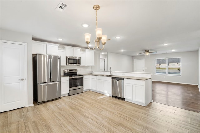 1505 S K Pl, Rogers, AR 72756 - kitchen with appliances with stainless steel finishes, a sink, a peninsula, light wood-style floors, and white cabinets