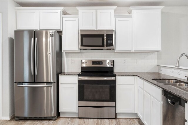 1505 S K Pl, Rogers, AR 72756 - kitchen featuring stainless steel appliances, a sink, dark stone counters, white cabinets, and backsplash