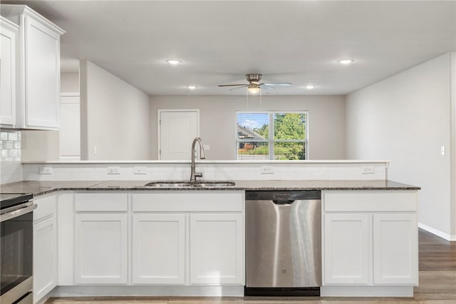 1505 S K Pl, Rogers, AR 72756 - kitchen with stainless steel appliances, a sink, ceiling fan, dark stone counters, and white cabinets
