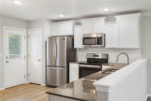 1505 S K Pl, Rogers, AR 72756 - kitchen featuring stainless steel appliances, a sink, light wood-type flooring, white cabinetry, and recessed lighting