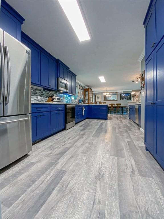108 Clive St, Berryville, AR 72616 - kitchen with appliances with stainless steel finishes, open floor plan, blue cabinets, light wood finished floors, and backsplash