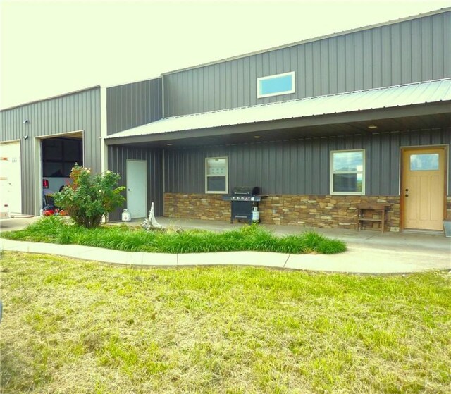 6611 Mc 4010, Everton, AR 72633 - rear view of property featuring stone siding, board and batten siding, metal roof, and a lawn
