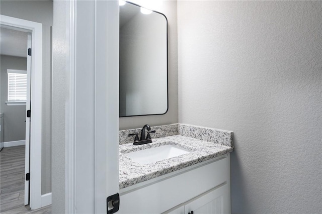 1909 Crump St, Pea Ridge, AR 72751 - bathroom with vanity, a textured wall, wood finished floors, and baseboards