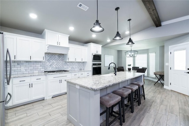 1909 Crump St, Pea Ridge, AR 72751 - kitchen featuring appliances with stainless steel finishes, decorative backsplash, white cabinetry, light wood finished floors, and recessed lighting