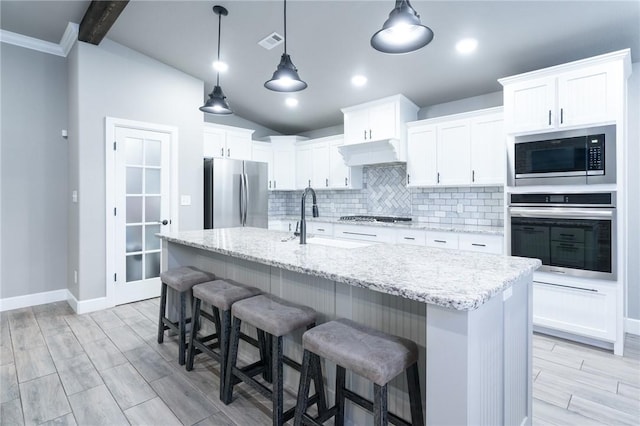 1909 Crump St, Pea Ridge, AR 72751 - kitchen featuring appliances with stainless steel finishes, a sink, tasteful backsplash, white cabinetry, and wood finish floors
