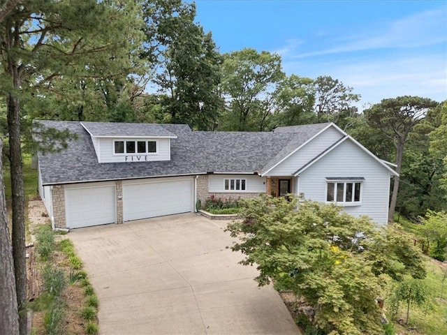 5 Augusta Ln, Holiday Island, AR 72631 - view of front of home featuring driveway, a shingled roof, stone siding, and view of scattered trees