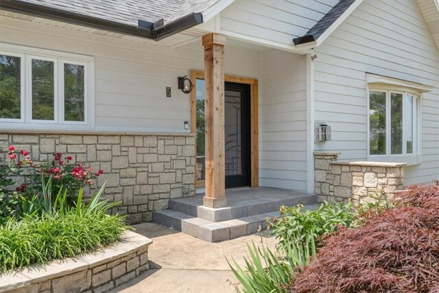 5 Augusta Ln, Holiday Island, AR 72631 - entrance to property featuring stone siding, roof with shingles, and covered porch