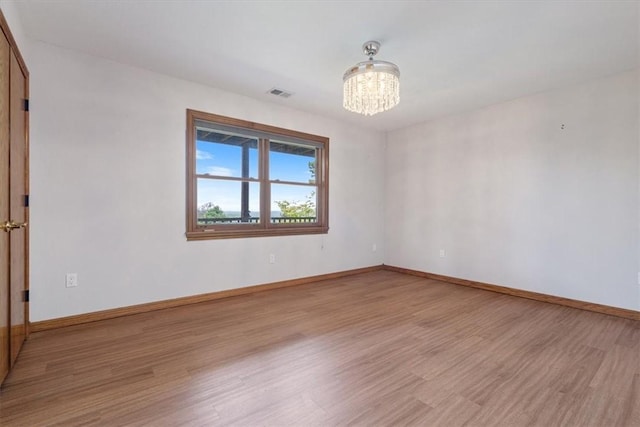 5 Augusta Ln, Holiday Island, AR 72631 - empty room featuring a chandelier, light wood-type flooring, and baseboards