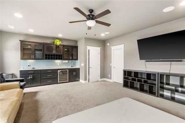 700 SE Yale St, Bentonville, AR 72712 - carpeted living room with beverage cooler, bar with sink, ceiling fan, and recessed lighting