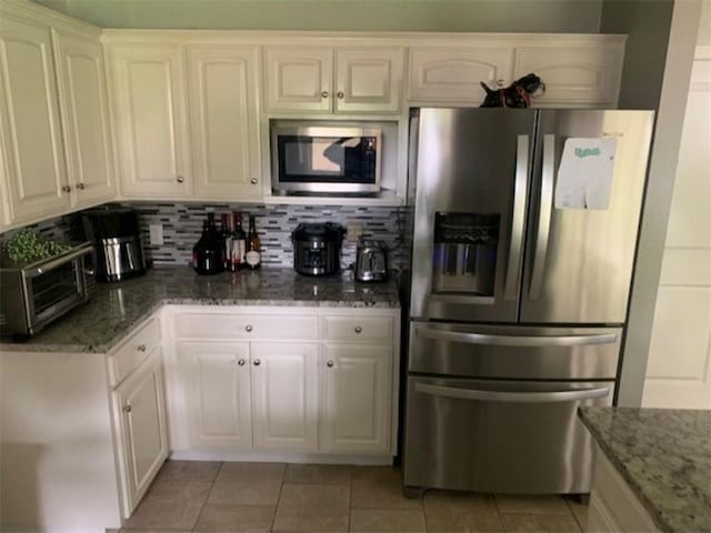 712 Carlton St, Springdale, AR 72762 - kitchen featuring appliances with stainless steel finishes, light tile patterned floors, stone counters, and white cabinets