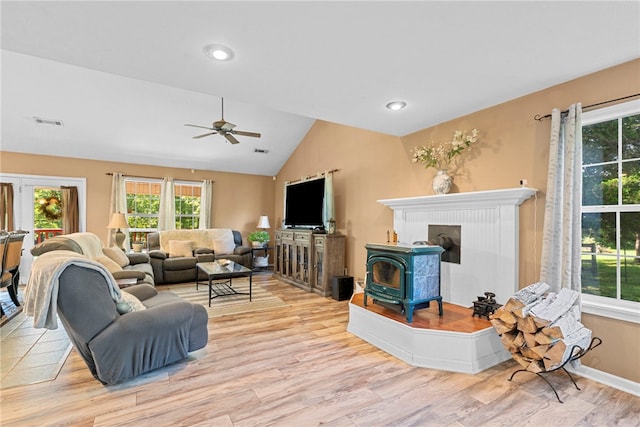 9225 Charles St, Rogers, AR 72756 - living room featuring a wood stove, plenty of natural light, vaulted ceiling, wood finished floors, and ceiling fan