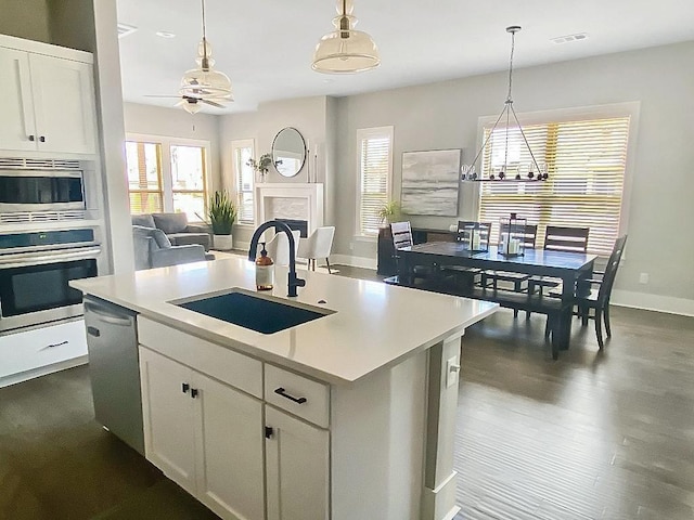 1432 Cannon Ln, Cave Springs, AR 72718 - kitchen with stainless steel appliances, open floor plan, a ceiling fan, light countertops, and hanging light fixtures