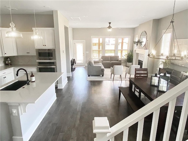 1432 Cannon Ln, Cave Springs, AR 72718 - kitchen featuring appliances with stainless steel finishes, ceiling fan, white cabinets, and dark wood finished floors
