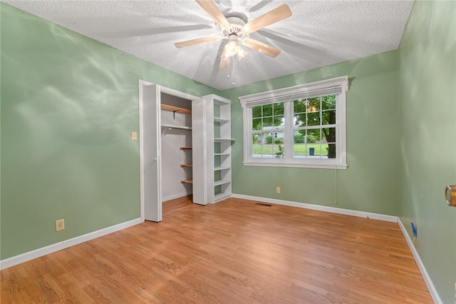 24 Meadow Lark Ln, Harrison, AR 72601 - unfurnished bedroom featuring a textured ceiling, wood finished floors, baseboards, ceiling fan, and a closet