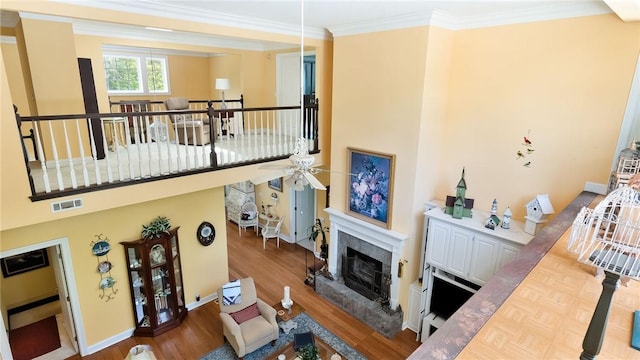 14559 Zimmerman Ln, Rogers, AR 72756 - living area featuring a ceiling fan, wood finished floors, a high end fireplace, crown molding, and baseboards
