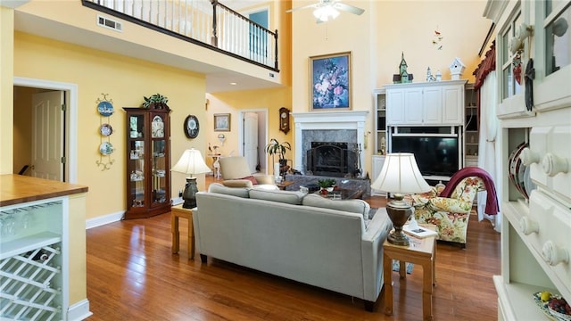 14559 Zimmerman Ln, Rogers, AR 72756 - living area featuring dark wood-type flooring, a ceiling fan, a fireplace, a high ceiling, and baseboards