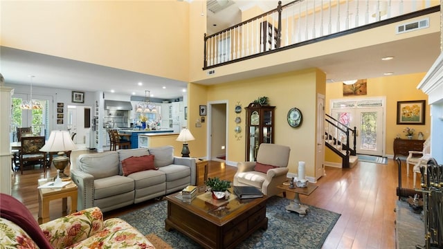 14559 Zimmerman Ln, Rogers, AR 72756 - living area featuring hardwood / wood-style flooring, a chandelier, a high ceiling, baseboards, and stairs