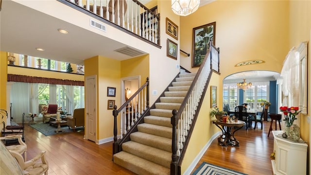 14559 Zimmerman Ln, Rogers, AR 72756 - stairs featuring a high ceiling, a chandelier, hardwood / wood-style flooring, plenty of natural light, and baseboards