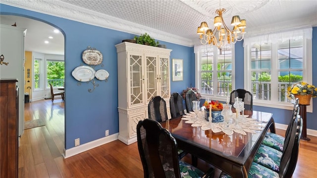 14559 Zimmerman Ln, Rogers, AR 72756 - dining room featuring arched walkways, a chandelier, wood finished floors, crown molding, and baseboards