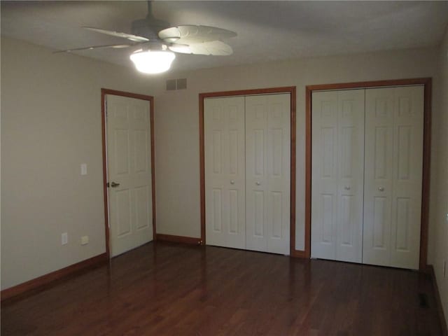 9 Rancho Vista Ln, Holiday Island, AR 72631 - unfurnished bedroom featuring two closets, wood finished floors, and a ceiling fan