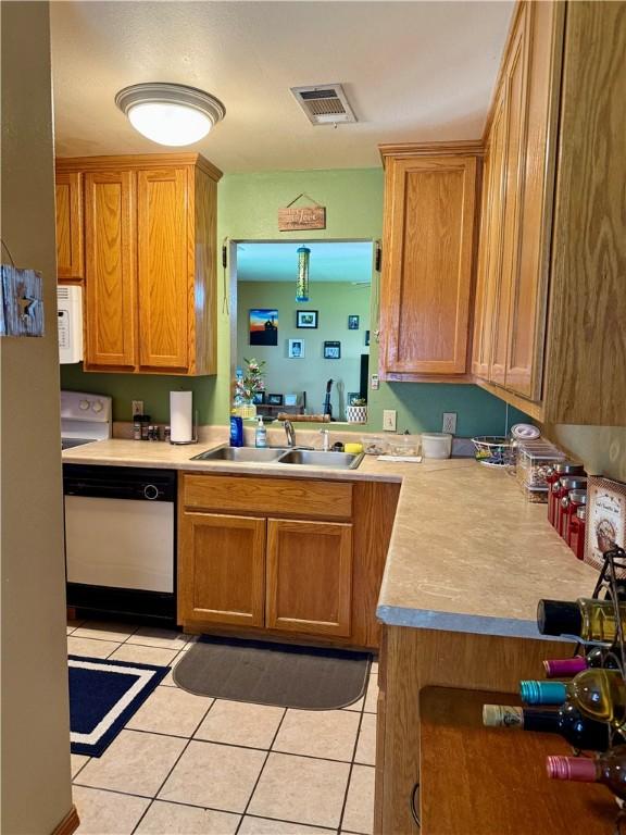 23933 J M Summers Rd, Summers, AR 72769 - kitchen featuring white microwave, dishwasher, light tile patterned floors, a sink, and light countertops