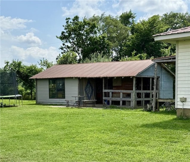 23933 J M Summers Rd, Summers, AR 72769 - view of front of property featuring a trampoline, metal roof, an exterior structure, and an outbuilding