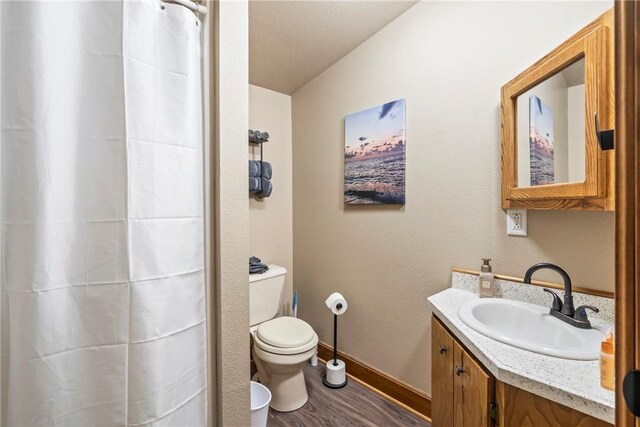 2480 N Saint Andrews Dr, Kansas, OK 74347 - full bath with wood finished floors, vanity, toilet, baseboards, and a shower with curtain