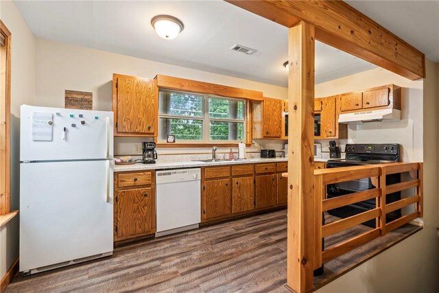 2480 N Saint Andrews Dr, Kansas, OK 74347 - kitchen with white appliances, dark wood-style flooring, light countertops, brown cabinets, and under cabinet range hood