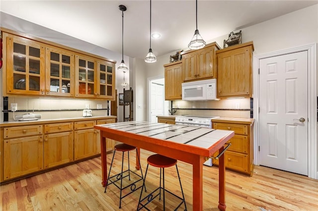 47 Rath Dr, Bella Vista, AR 72715 - kitchen with white appliances, tile counters, light wood finished floors, decorative backsplash, and glass insert cabinets
