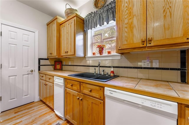 47 Rath Dr, Bella Vista, AR 72715 - kitchen featuring white dishwasher, a sink, tile countertops, decorative backsplash, and light wood-style flooring