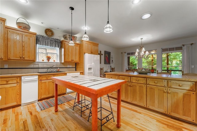 47 Rath Dr, Bella Vista, AR 72715 - kitchen with white fridge with ice dispenser, tile countertops, light wood-style flooring, a chandelier, and pendant lighting